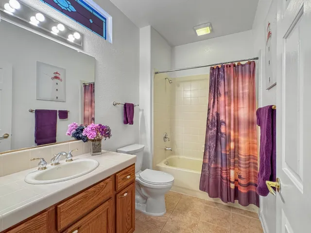 a bathroom with a sink vanity mirror and tub