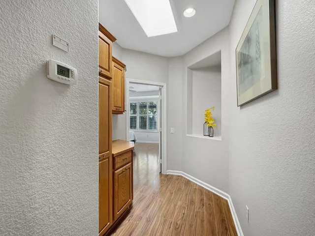 a view of a hallway with wooden floor and furniture