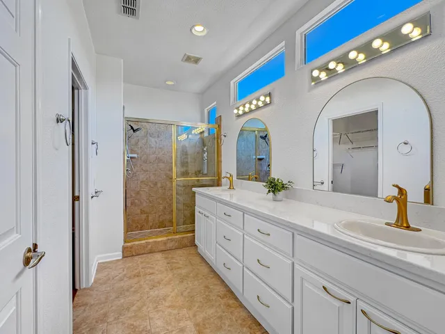 a spacious bathroom with a double vanity sink and a mirror