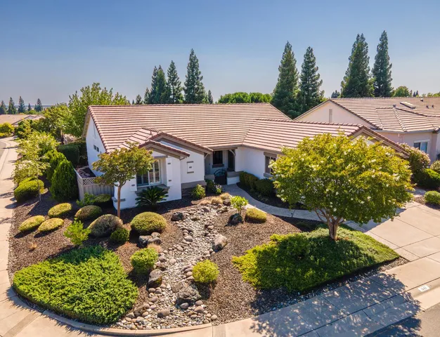 a view of a house with a small yard and potted plants