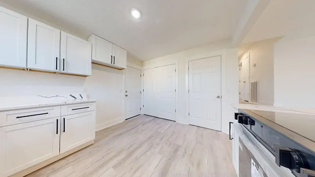 a view of cabinets a wooden floor and a window in the kitchen