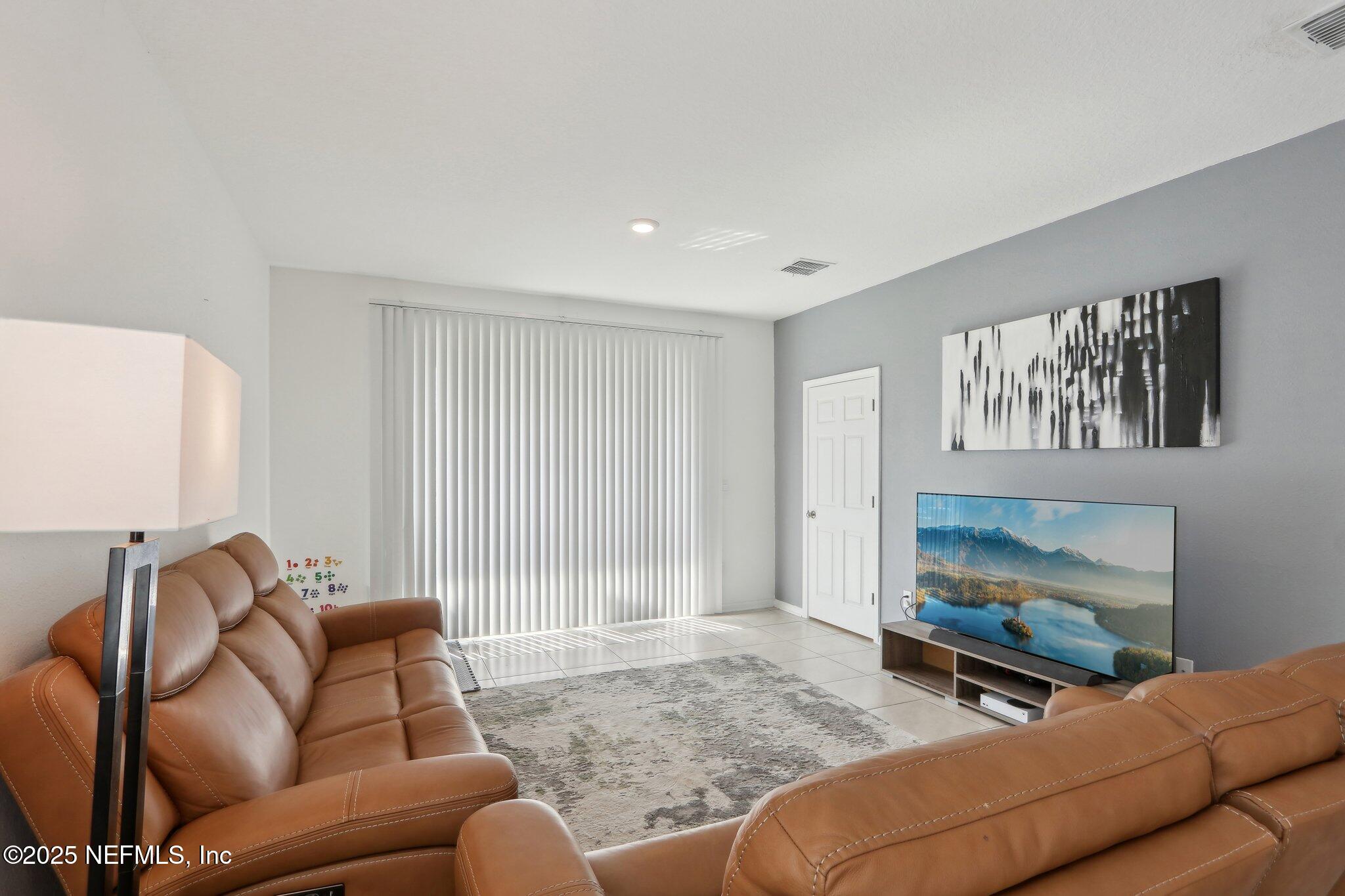 4932 Earthshine Road Jacksonville, FL 32256 - Photo 3 of 28 a living room with furniture and a flat screen tv