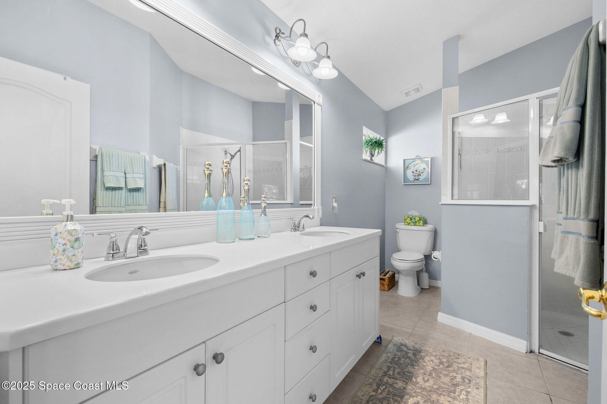 7248 Broderick Drive Melbourne, FL 32940 - Photo 16 of 51 a spacious bathroom with a double vanity sink and a mirror