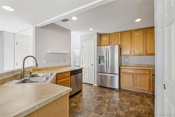 a kitchen with stainless steel appliances granite countertop a refrigerator and a sink