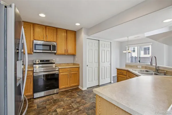 a kitchen with stainless steel appliances granite countertop a stove a sink and a microwave