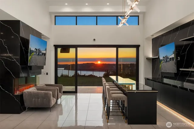 a living room with couches a flat screen tv and a floor to ceiling window