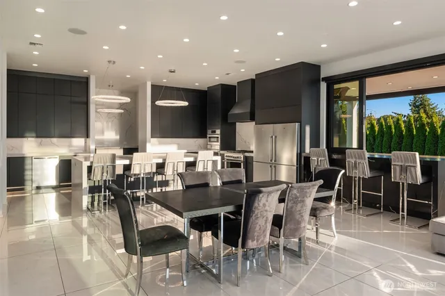 a dining room with stainless steel appliances lots of white furniture a chandelier table and chairs