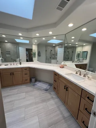 a large kitchen with a large counter top a sink stainless steel appliances