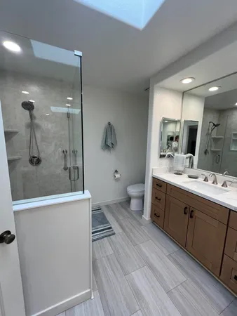 a bathroom with a double vanity sink mirror and shower