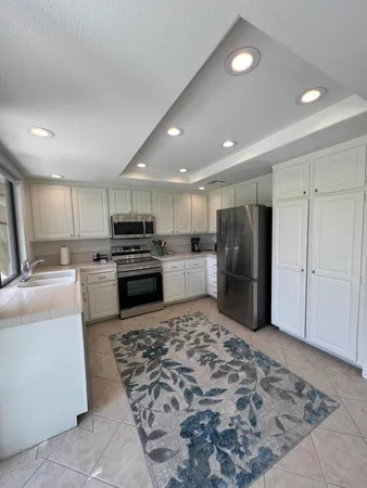 a kitchen with stainless steel appliances granite countertop a refrigerator and a stove top oven