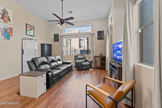 a living room with furniture flat screen tv and wooden floor
