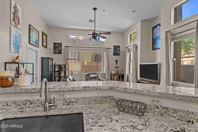 a view of a hallway with a granite counter top and living room