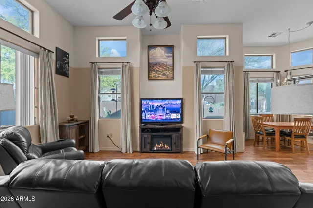 a kitchen with stainless steel appliances granite countertop a refrigerator a sink a stove a dining table and chairs