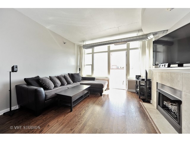 909 West Washington Boulevard, Unit 901 Chicago, IL 60607 - Photo 2 of 10 a living room with furniture and a fireplace