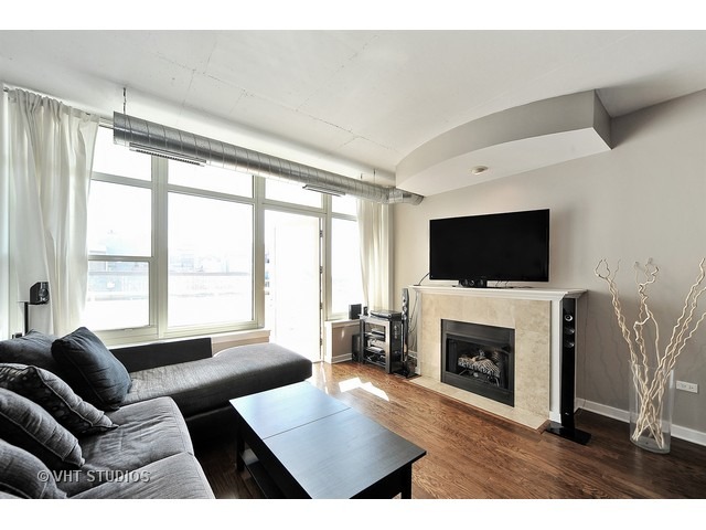909 West Washington Boulevard, Unit 901 Chicago, IL 60607 - Photo 3 of 10 a living room with furniture a flat screen tv and a fireplace