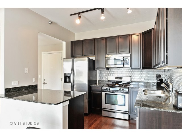 909 West Washington Boulevard, Unit 901 Chicago, IL 60607 - Photo 4 of 10 a kitchen with kitchen island stainless steel appliances a sink stove and refrigerator