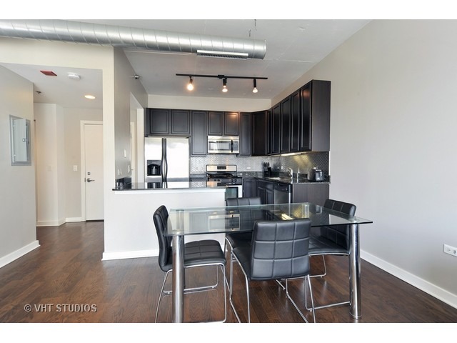 909 West Washington Boulevard, Unit 901 Chicago, IL 60607 - Photo 6 of 10 a kitchen with stainless steel appliances granite countertop a dining table chairs and granite counter top