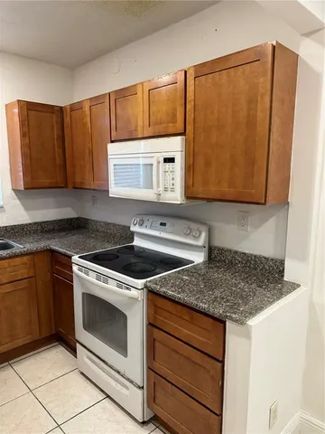 a kitchen with stainless steel appliances granite countertop a sink stove and microwave