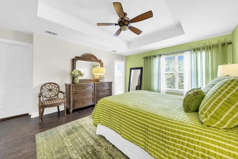 a bedroom with a bed a chandelier and a dresser