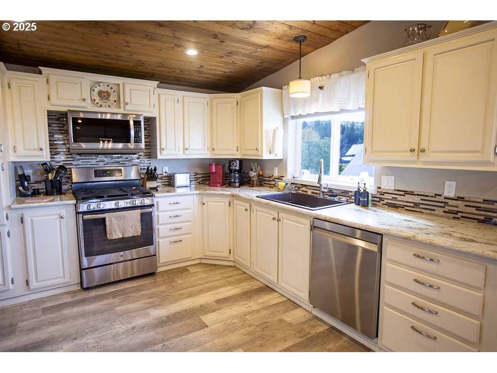 1208 Hill Street Cove, OR 97824 - Photo 3 of 33 a kitchen with stainless steel appliances granite countertop a stove a sink dishwasher and a microwave