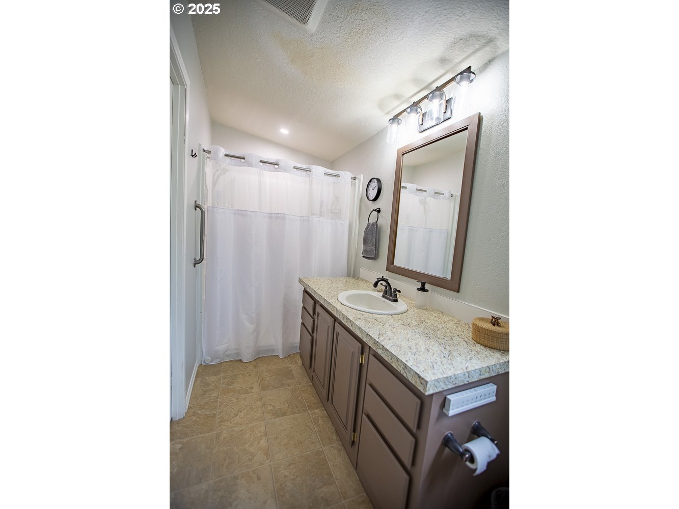 1208 Hill Street Cove, OR 97824 - Photo 9 of 33 a bathroom with a granite countertop sink a mirror and shower
