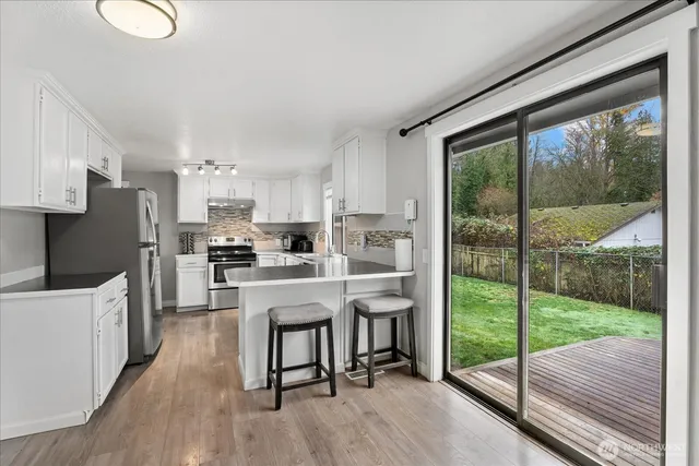 a kitchen view with a table chairs refrigerator and cabinets