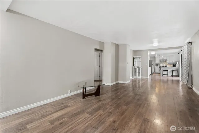 a view of empty room with wooden floor