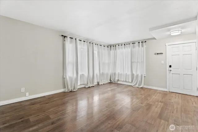 a view of a room with wooden floor and window