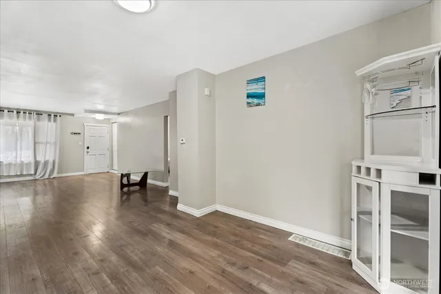 a view of empty room with wooden floor