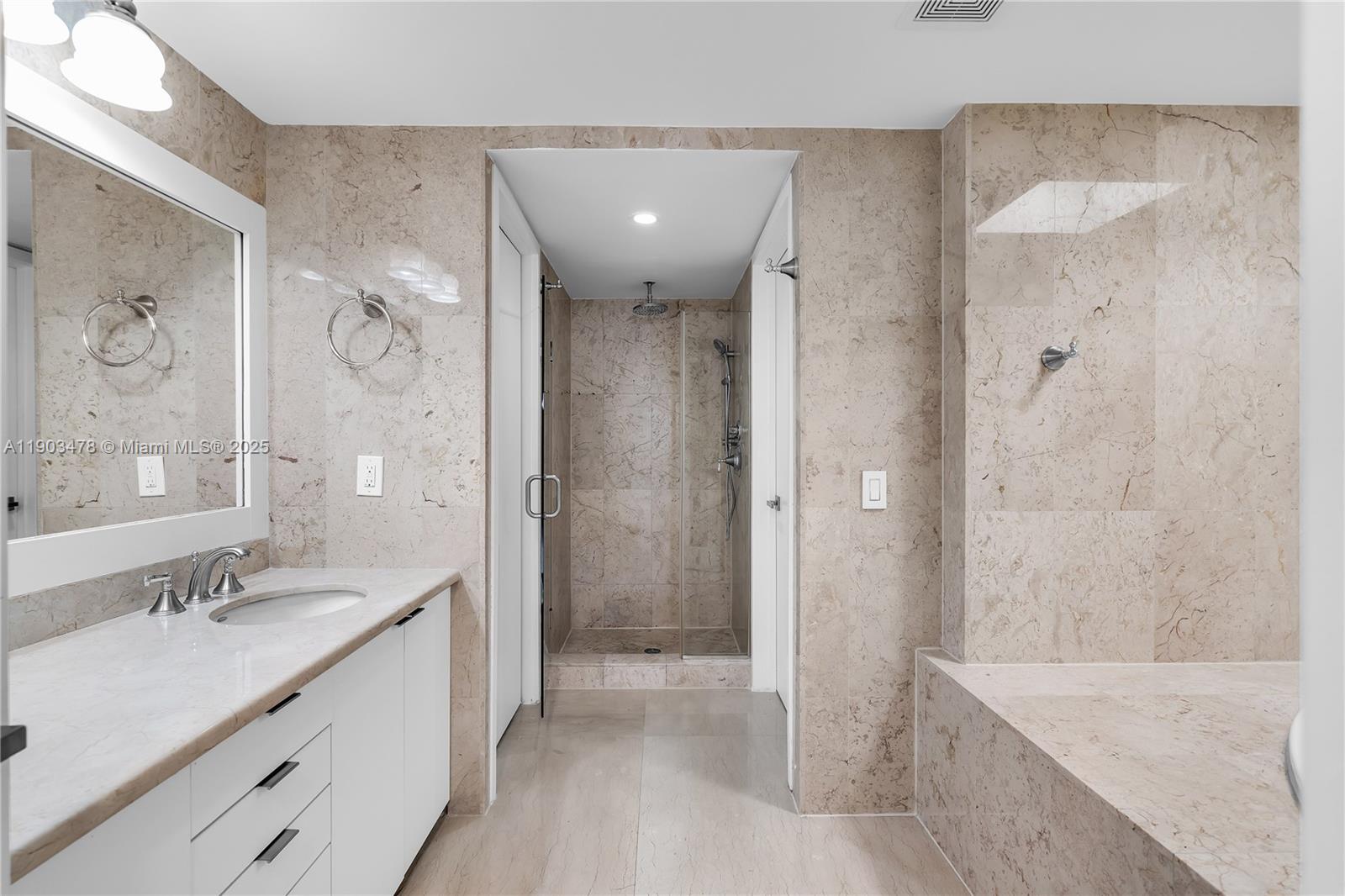 141 Crandon Boulevard, Unit 242 Key Biscayne, FL 33149 - Photo 25 of 42 a bathroom with a granite countertop sink a shower and a mirror