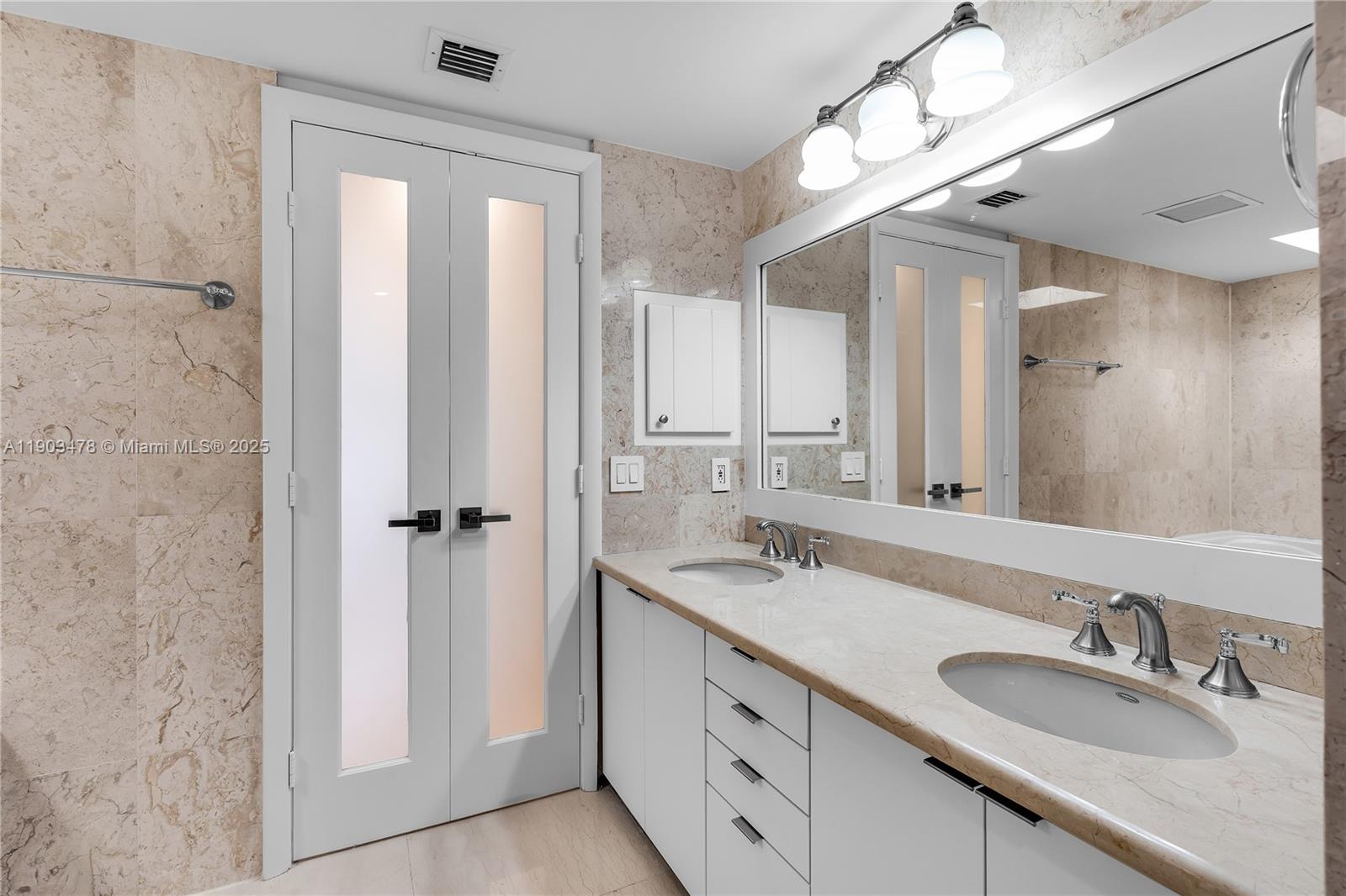 141 Crandon Boulevard, Unit 242 Key Biscayne, FL 33149 - Photo 26 of 42 a bathroom with double sink and a mirror