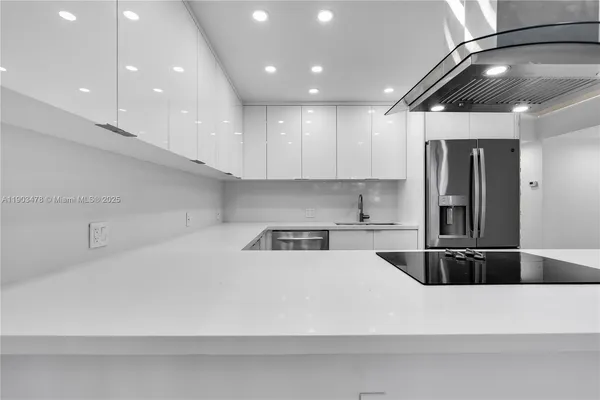 a kitchen with stainless steel appliances granite countertop a refrigerator and a stove