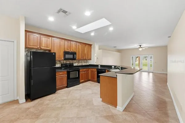 a kitchen with stainless steel appliances granite countertop a refrigerator a sink a stove and oven