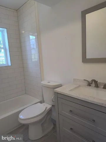 a bathroom with a granite countertop toilet a sink and bathtub