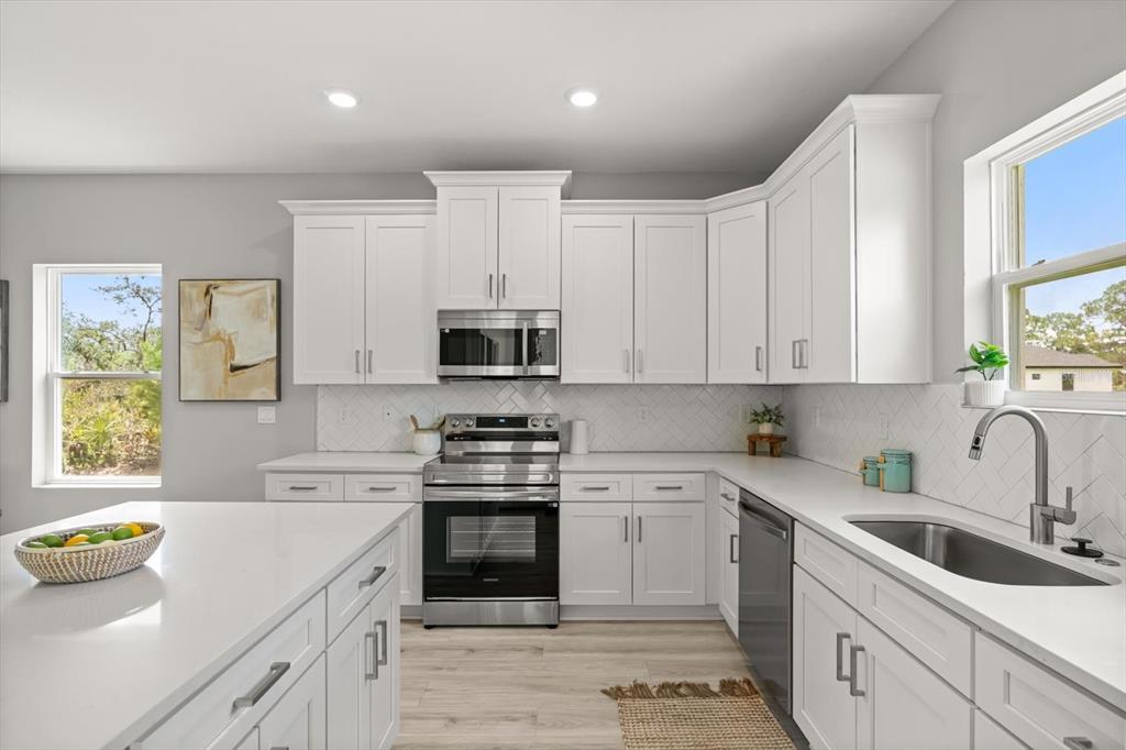 0 Marion Oaks Manor Ocala, FL 34473 - Photo 9 of 24 a kitchen with stainless steel appliances a sink a stove a microwave a sink a refrigerator and cabinets