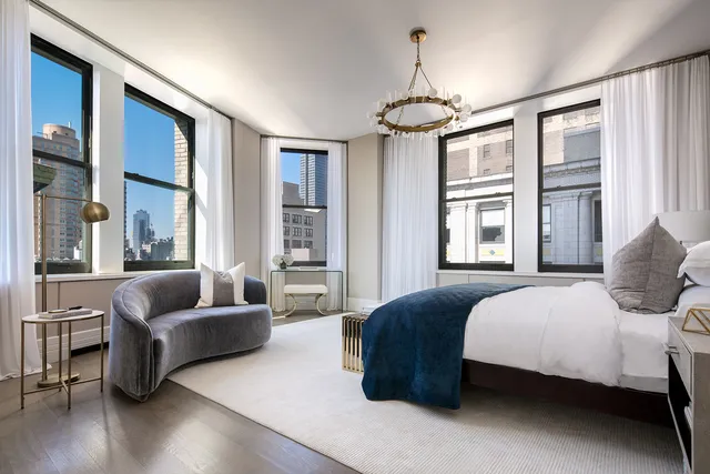 a bedroom with a bed couches and wooden floor