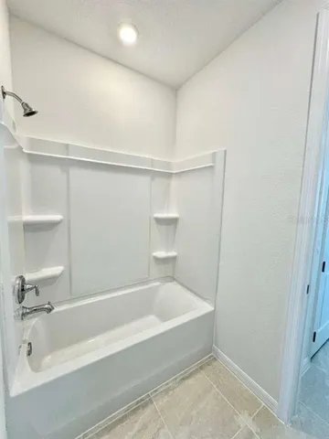 a white bath tub sitting next to a white sink and vanity