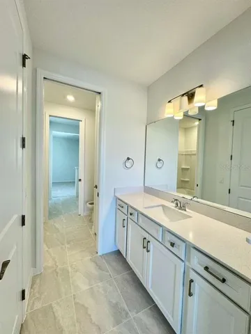 a spacious bathroom with a granite countertop sink mirror and a