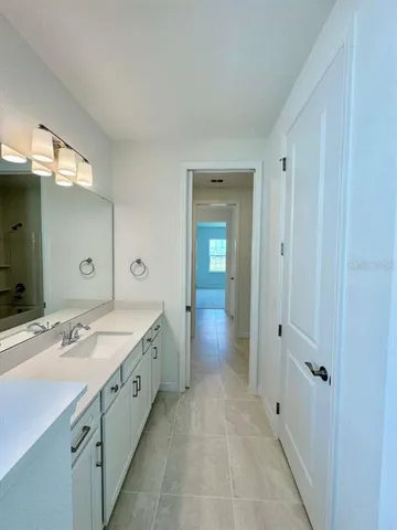 a spacious bathroom with a double vanity sink and mirror with shower