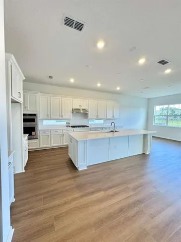 a large kitchen with a center island and stainless steel appliances