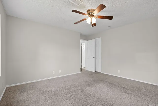 an empty room with chandelier fan