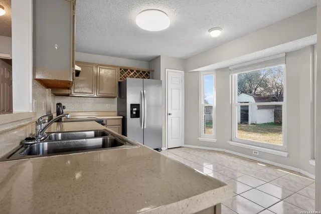 a kitchen with kitchen island a counter top space a sink and stainless steel appliances