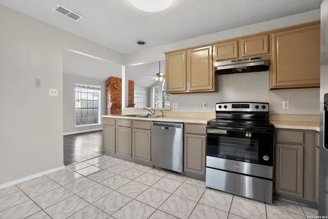 a kitchen with stainless steel appliances granite countertop a stove a sink and a refrigerator