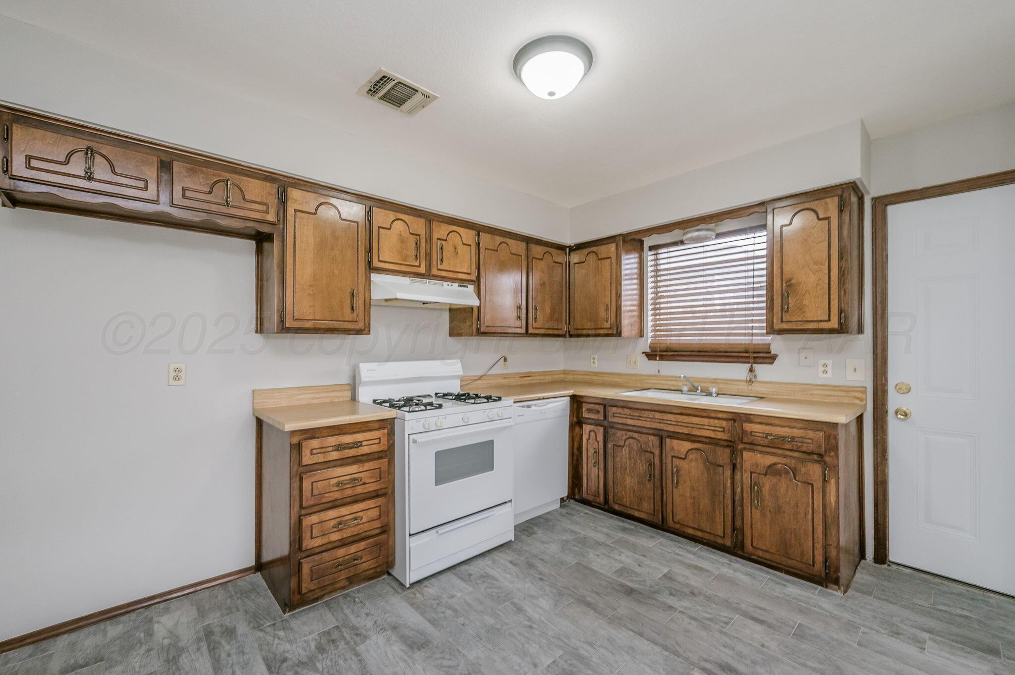 1624 Lockney Street Amarillo, TX 79106 - Photo 4 of 16 a large kitchen with stainless steel appliances granite countertop a stove and a sink