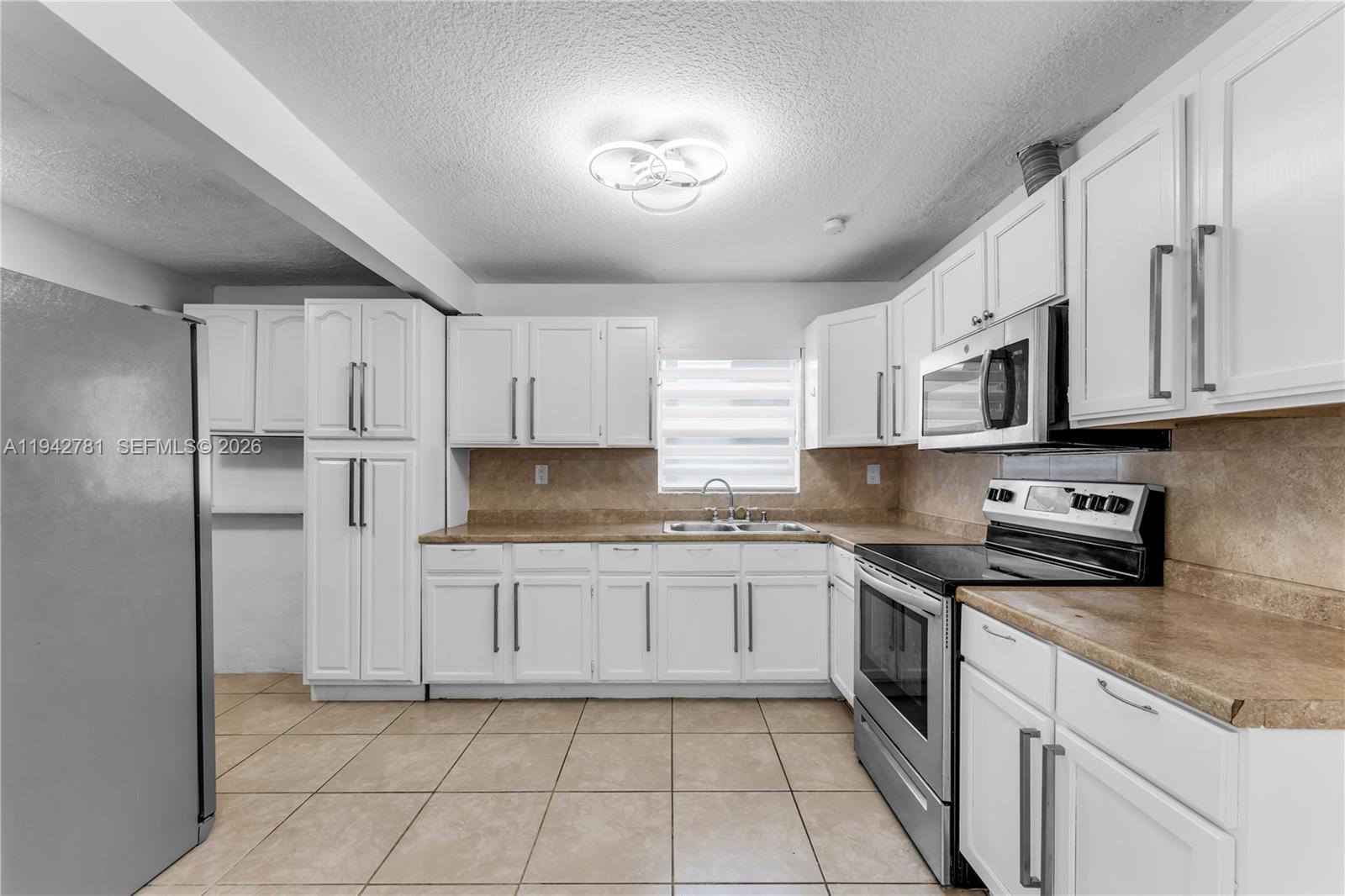 15805 Southwest 300th Terrace Homestead, FL 33033 - Photo 40 of 52 a kitchen with stainless steel appliances granite countertop a refrigerator and a stove top oven