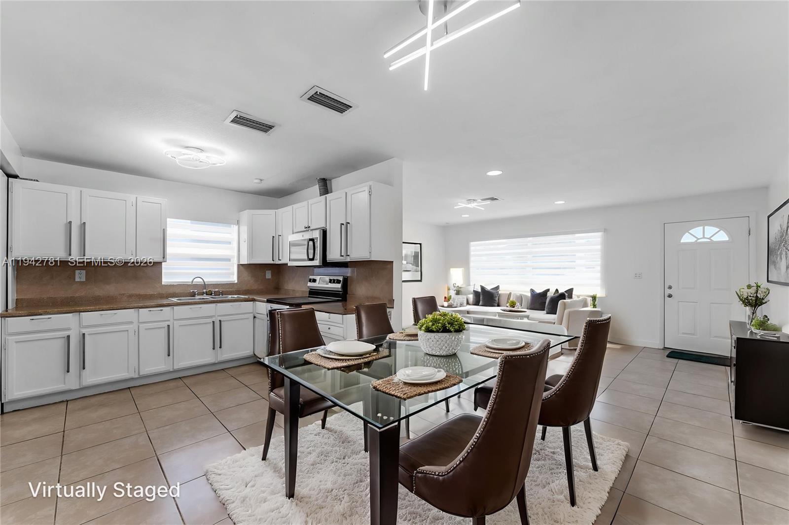 15805 Southwest 300th Terrace Homestead, FL 33033 - Photo 6 of 52 a kitchen with a dining table chairs and white cabinets