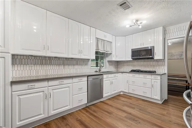 a kitchen with granite countertop white cabinets and white appliances