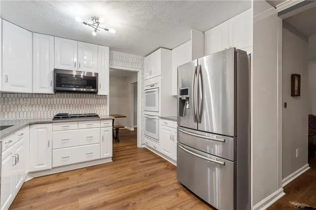 a kitchen with stainless steel appliances a refrigerator sink and microwave