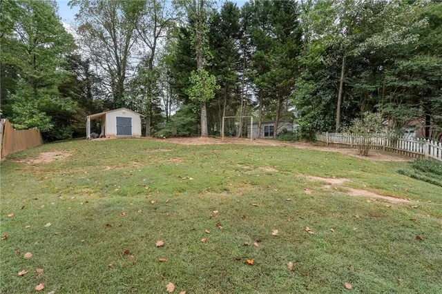 an aerial view of a house with swimming pool and large trees