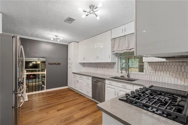 a kitchen with stainless steel appliances a stove a sink and a refrigerator